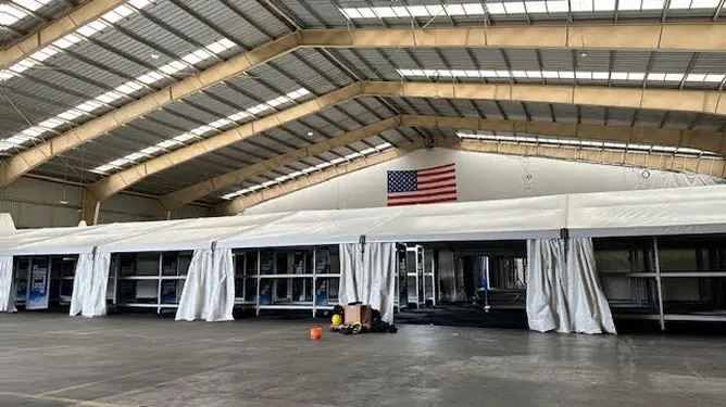 Bed-Stay-slaapplekken voor 400 personen in een grote hal voor US TRANSCOM, met de Amerikaanse vlag aan de wand